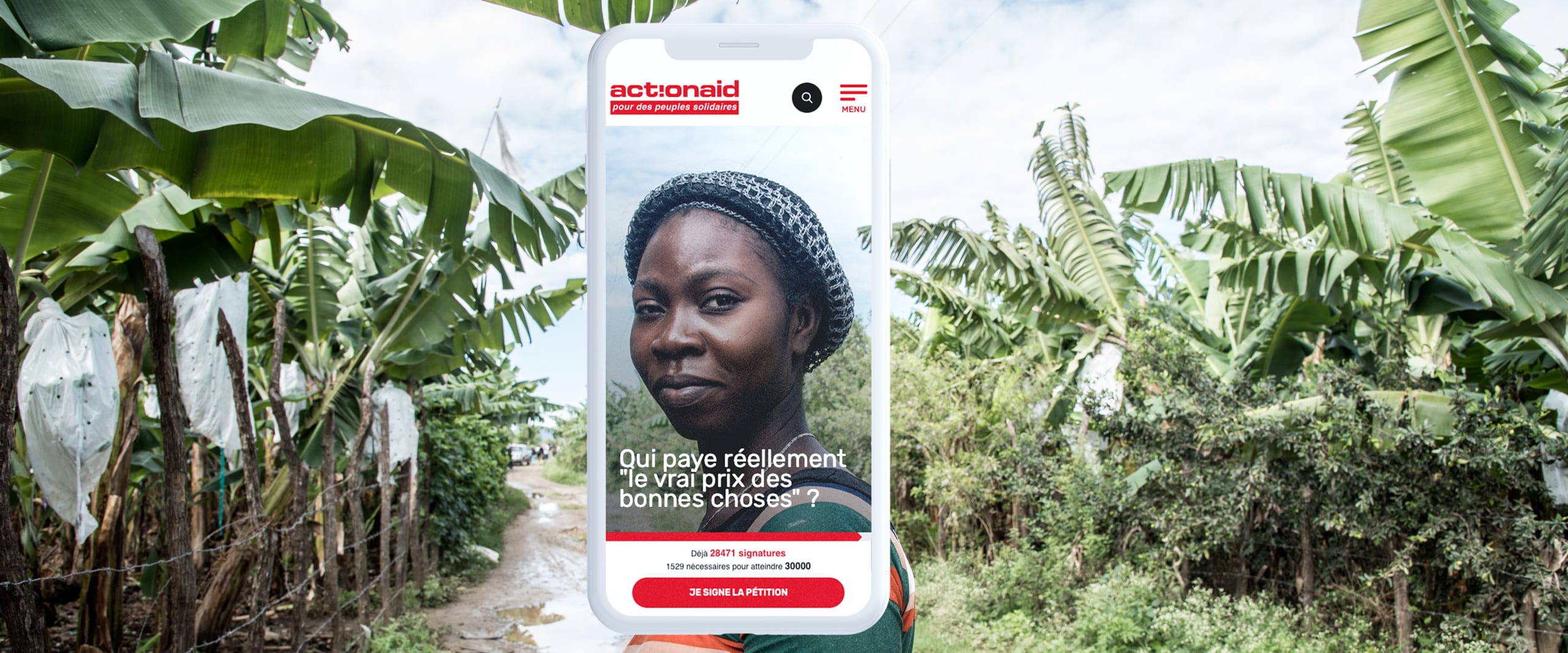 Image conceptuelle d'un énorme smartphone s'intégrant dans un paysage rural avec des bananiers. Sur l'écran, une campagne d'ActionAid présente le portrait d'une femme avec le texte 'Qui paye réellement le vrai prix des bonnes choses ?'. L'écran affiche également le nombre de signatures collectées pour une pétition. La juxtaposition de la technologie moderne avec l'environnement naturel évoque un message sur l'impact social et économique de l'agriculture mondialisée.